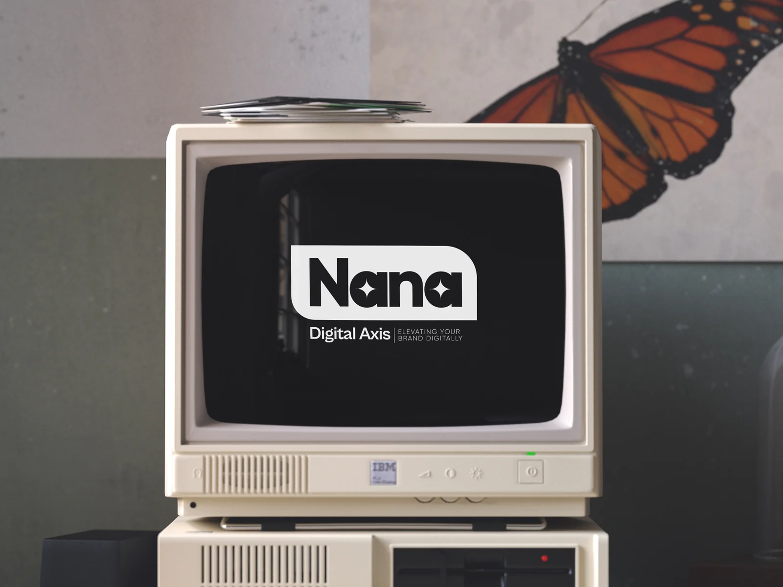 A retro desktop computer on a studio desk showing the Nana Digital Axis logo — one of Bethel Mozart's identity projects